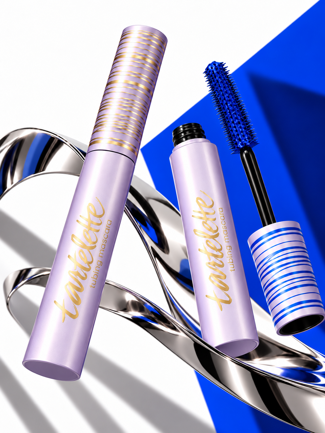 Two full-size lavender tubing mascara tubes in a studio composition